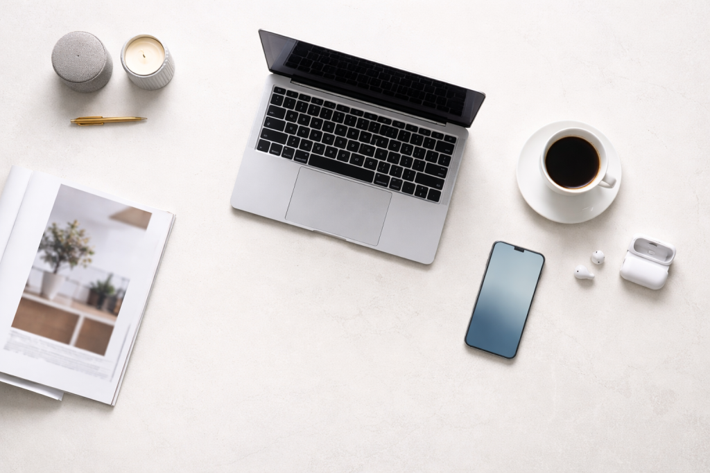 Standard blog-header: et stilrent skrivebord med laptop, kaffekop, telefon og et par designede produkter – fleksibel scene, der kan passe til mange artikler om brands og shopping.